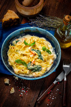 Seafood Pasta With Shrimp And Basil In Cream Sauce On A Plate On A Wooden Background