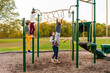 © Sarah Rypma - Mother assisting her daughter on the playgorund monkey bars