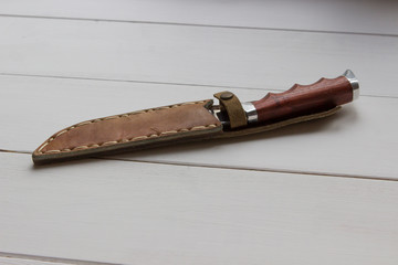 a hunting knife in a leather anklet is on the table