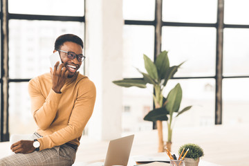 Poster - Black guy talking on phone sitting on the table
