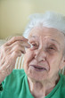 © berna_namoglu - a senior woman applying eyedrops into her eyes by herself