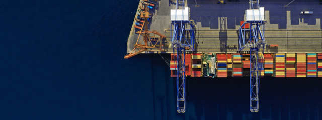 Aerial drone ultra wide top down photo of commercial container terminal with cranes loading shipment to tanker ships in Mediterranean port