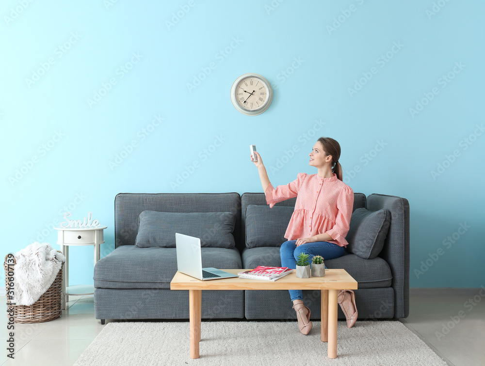 Young woman in room with operating air conditioner