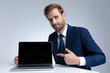 © Viorel Sima - Young businessman smiling and pointing to his laptop