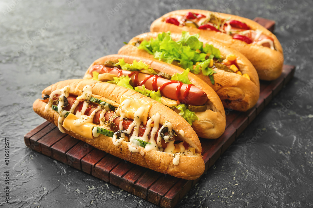 Tasty hot dogs on dark table