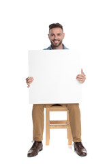 Canvas Print - happy young casual man holding empty board