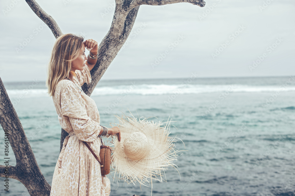 Obraz na płótnie Boho model wearing dress and straw hat on the beach w salonie