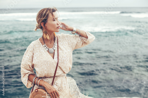 Fotomural Boho model wearing dress and straw hat on the beach