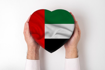 Wall Mural - Flag of United Arab Emirates on a heart shaped box in a male hands. White background