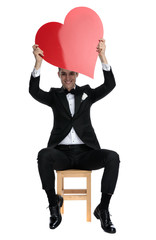 Poster - happy young elegant man holding big red heart