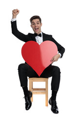 Poster - enthusiastic young groom holding big red heart