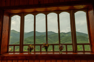 Canvas Print - Summer field and mountains seen through the window