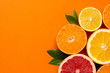 Citruses fruits on orange background with copyspace, fruit flatlay, summer minimal compositon with grapefruit, lemon, mandarin and orange