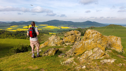 a hiker with a backpack near the city of kassel on a mountain. the stones have the name helfensteine