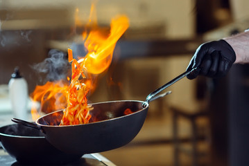 Modern kitchen. Cooks prepare meals on the stove in the kitchen of the restaurant or hotel. The fire in the kitchen.