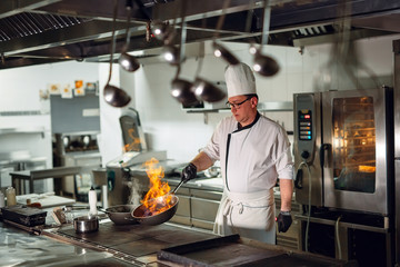 Modern kitchen. Cooks prepare meals on the stove in the kitchen of the restaurant or hotel. The fire in the kitchen.