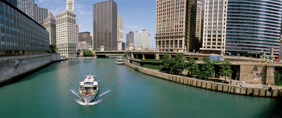 this is a tour boat on the chicago river during summer. the chicago tribune building, chicago sun ti