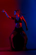 © ardasavasciogullari - Black dressed and braided hair woman dancing on a blue and red background.