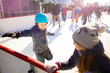 girl in blue helmet learns to skate on ice