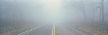This Is Fossy Road In A Fog.  It Signifies Hazardous Driving Conditions As You Can Only See A Few Feet Of The Road And The Way Ahead Is Obscured By The Fog.