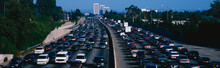 This Is Rush Hour Traffic On The 405 Freeway At Sunset. There Are 10 Lanes Of Traffic Total Showing Both Sides Of The Freeway. There Are Cars Stopped In Every Lane.