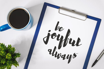 Wall Mural - Motivational and Inspirational Quotes. Be Joyful Always. Still Life of Clipboard on Work Desk.
