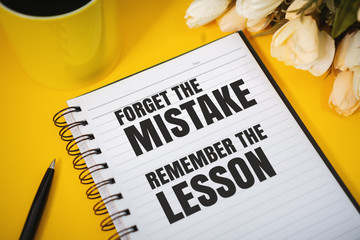 Wall Mural - Motivational and Inspirational Quotes. Forget The Mistake, Remember The Lesson. Still Life of Notebook on Work Desk.