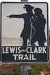 This is a road sign that marks the Lewis and Clark Trail. There is a silhouetted graphic on the sign of the explorers, Lewis and Clark against a white background.