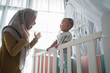 © Odua Images - asian muslim mother play peek a boo with her son at home