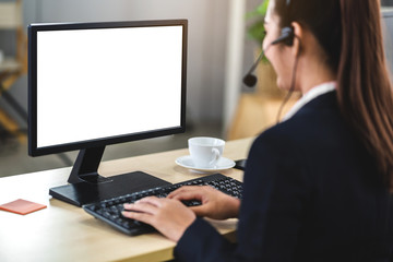 Beautiful businesswoman customer support services working with headset and computer with white mockup blank screens at call center