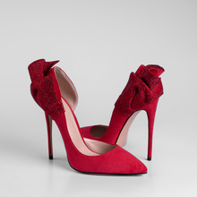 Womens Red Suede High Heel Shoes With Decorative Rhinestone Bow On The Heel. Close-up Side View On A White Background