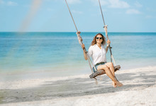 Beautiful Young Curly Funny Girl On A Swing On A Tropical Beach,