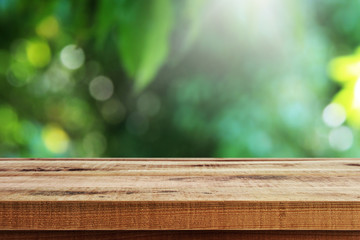 Wall Mural - Blurred fresh nature garden background and empty wooden table.