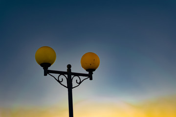 Bright and colorful lights on the waterfront at dusk and night, seascape, green and yellow light, blue starry sky. Russia, the village of Divnomorskoye. Round, glowing balls.