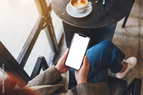 Fotografía Top view mockup image of a woman holding black mobile phone with blank desktop s
