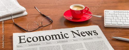 Cuadros en Lienzo A newspaper on a wooden desk - Economic News