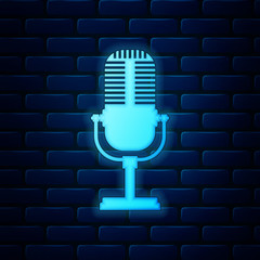 Glowing neon Microphone icon isolated on brick wall background. On air radio mic microphone. Speaker sign. Vector Illustration