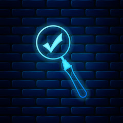 Poster - Glowing neon Magnifying glass and check mark icon isolated on brick wall background. Magnifying glass and approved, confirm, done, tick, completed symbol. Vector Illustration