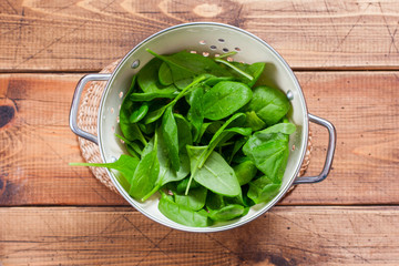 Step by step preparation of spinach salad with egg and cheese, step 2 - cleaning washing spinach for salad, top view, selective focus