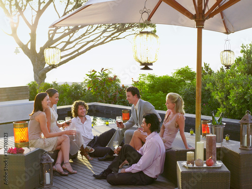 Fotomural Friends enjoying a beautiful evening together drinking wine and enjoying convers