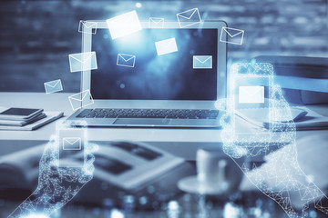 Desktop computer background in office and flying envelops hologram drawing. Multi exposure. Electronic mail concept.