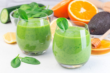 Green detox smoothie with avocado, spinach, cucumber, orange, lemon and honey, horizontal