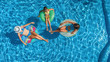 © Iuliia Sokolovska - Family in swimming pool aerial drone view from above, happy mother and kids swim on inflatable ring donuts and have fun in water on family vacation, tropical holidays on resort