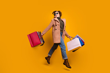 Poster - Full body profile photo of pretty shopper lady walk shopping center carry many packs wear sun specs casual pink coat pullover jeans leopard print shoes isolated yellow color background