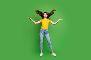 Wall Mural - Full length photo of pretty funny lady sending air kisses making crazy facial expression throwing hair up wear casual yellow t-shirt jeans isolated bright green color background