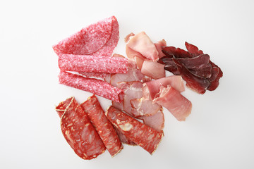 Wall Mural - top view of fresh delicious assorted sliced meat isolated on white