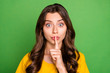 Close-up portrait of her she nice attractive lovely charming mysterious wavy-haired girl showing shh sign don't speak isolated on bright vivid shine vibrant green color background