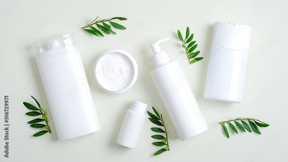Set of SPA cosmetic containers and bottles branding mockup and green leaves. Top view shampoo bottle, lotion container, shower gel, essential oil, body cream. Bath beauty products packaging - obrazy, fototapety, plakaty 