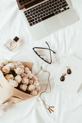 Wall Mural - Fashion, beauty, lifestyle blogger home office workspace. Laptop, roses bouquet, female accessories, notebook on white linen. Flat lay, top view freelancer concept.