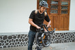asian young man preparing her folding bike before go in front the house